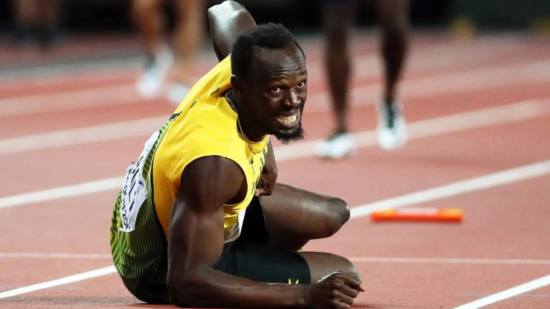 Usain Bolt se trastabilló y cayó al suelo entre gestos de dolor.