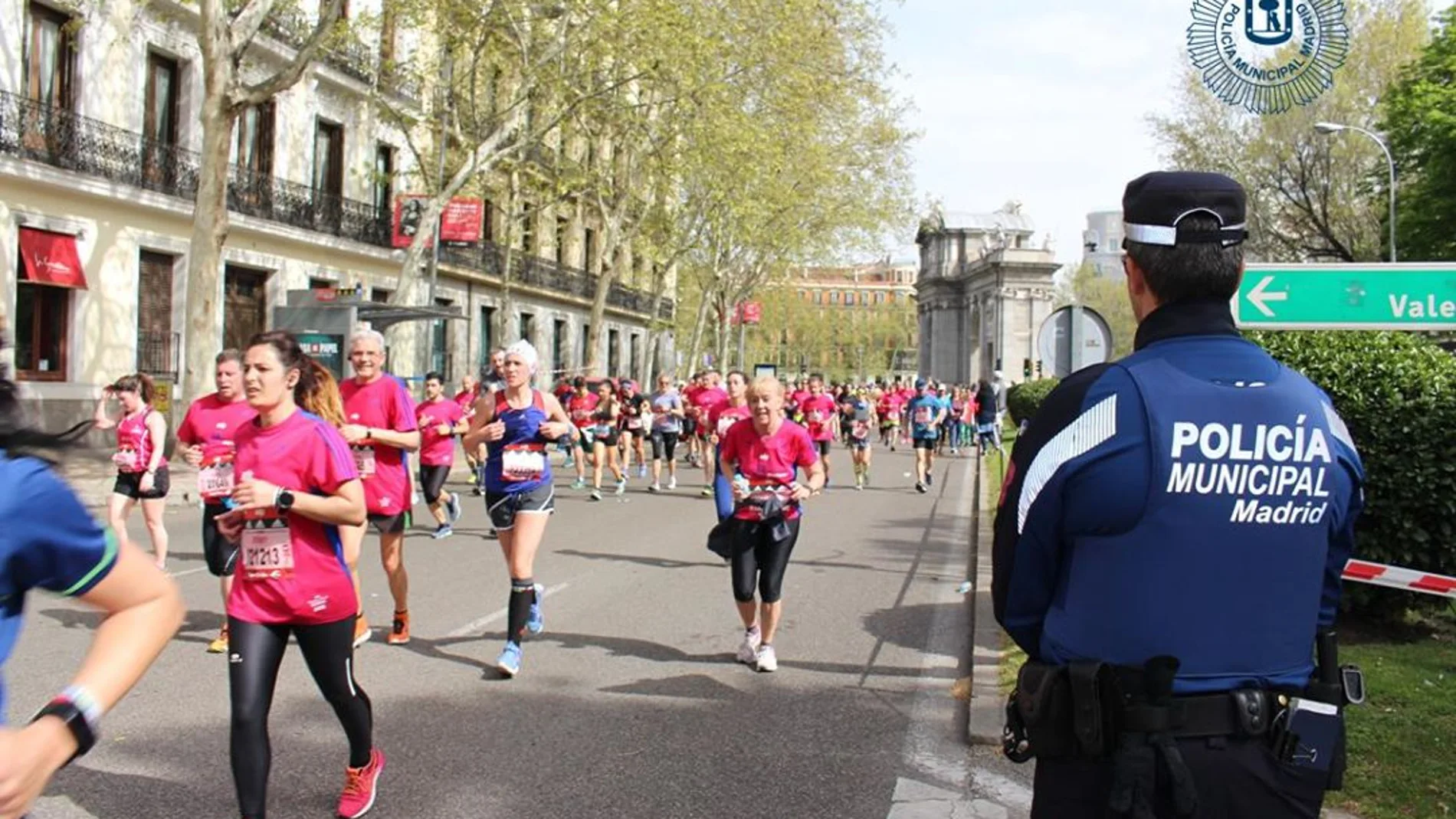 Un agente de la Policía Municipal vigila durante el paso de los corredores del Maratón de Madrid