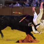 El diestro sevillano Javier Jiménez, cogido por el segundo de su lote, durante la corrida celebrada esta tarde en la plaza de toros de la Maestranza de Sevilla