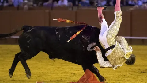 El diestro sevillano Javier Jiménez, cogido por el segundo de su lote, durante la corrida celebrada esta tarde en la plaza de toros de la Maestranza de Sevilla