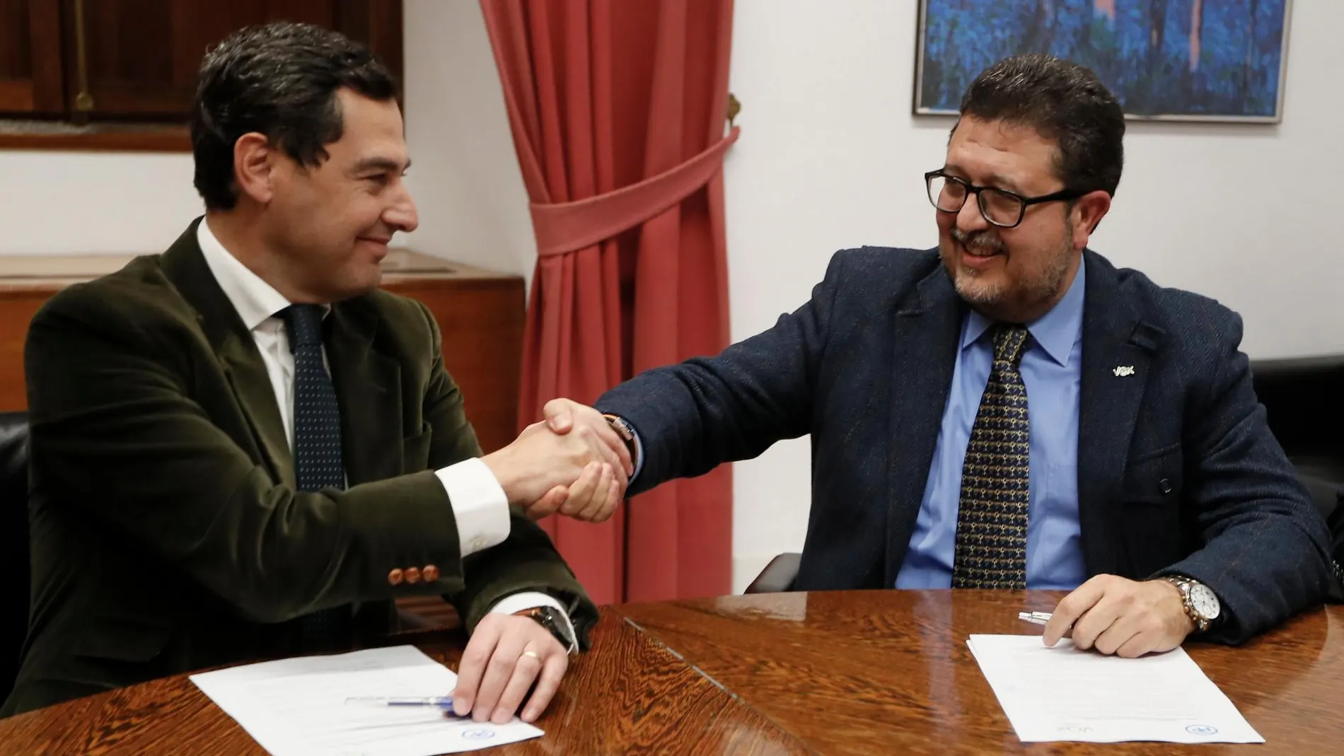 El presidente del PP-A, Juanma Moreno, estrecha la mano con el líder andaluz de Vox, Francisco Serrano,/Efe