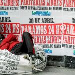 Un «sin techo» duerme en Buenos Aires junto a un local de cambio cubierto con carteles de una huelga general para mañana / Reuters