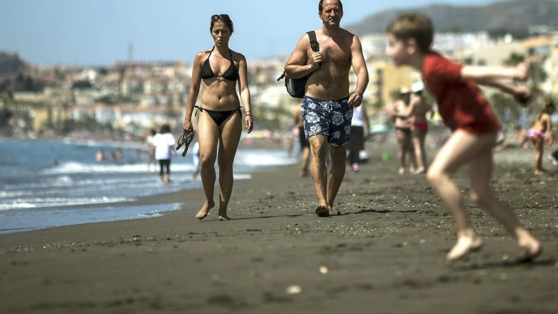 Imagen de archivo de una pareja que pasea por la playa malagueña del Rincón de la Victoria ante el buen tiempo en la Costa del Sol