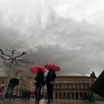 Dos personas se protegen del agua con un paraguas esta mañana en al Plaza del Castillo de Pamplona