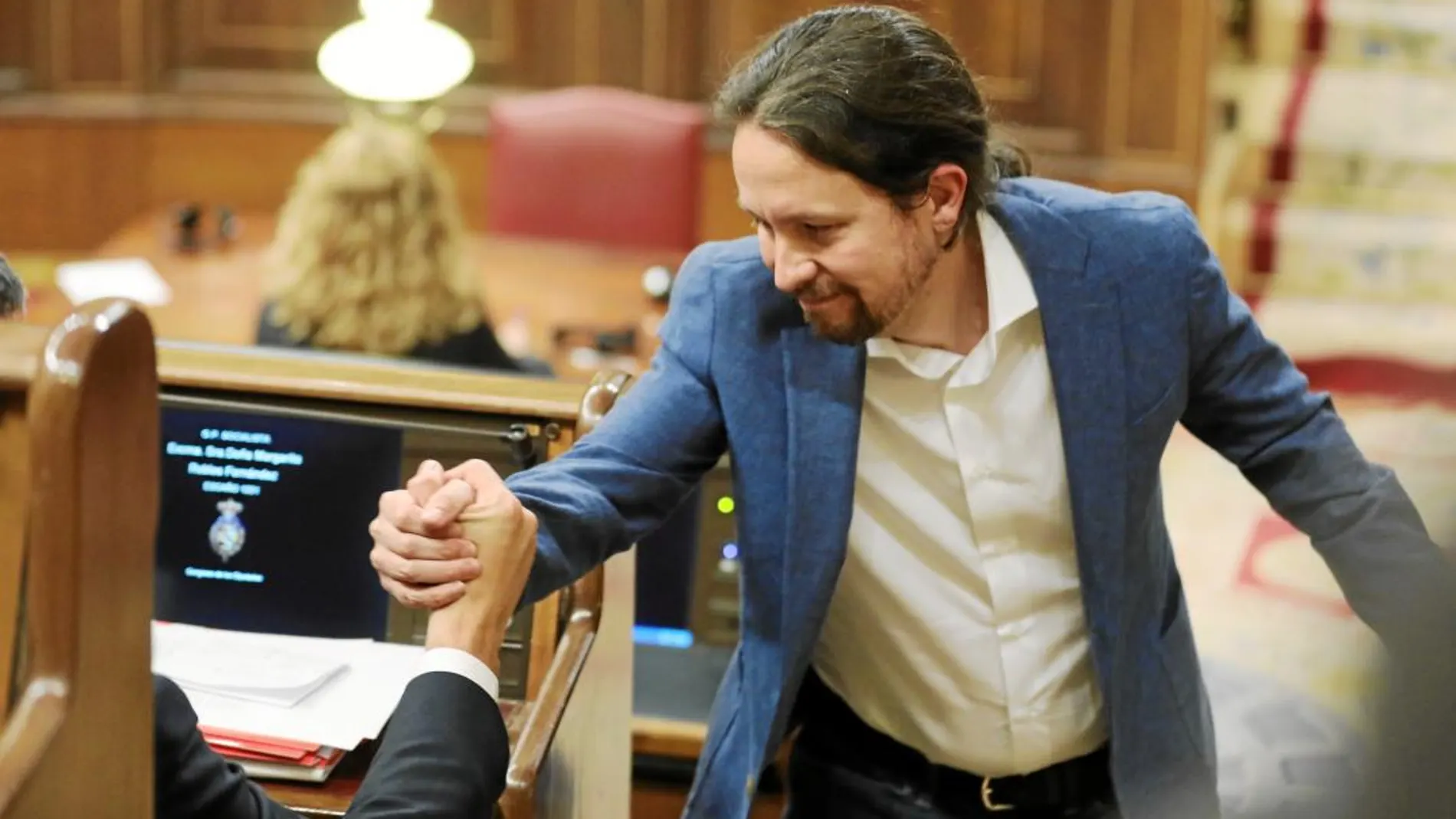 Pablo Iglesias estrecha la mano del secretario general del PSOE, Pedro Sánchez, a su llegada al Congreso