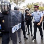 Agentes antidisturbios de la Policía Nacional y de los Mossos d' Esquadra discuten frente al Instituto Can Vilumara de L'Hospitalet de Llobregat