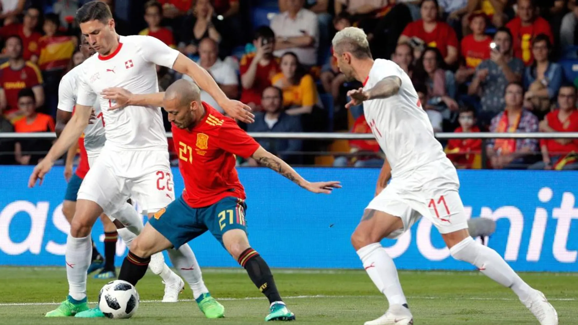 El centrocampista de España David Silva con el balón ante los jugadores de Suiza, Fabian Schar y Valon Berhami durante el partido amistoso / Foto: Efe
