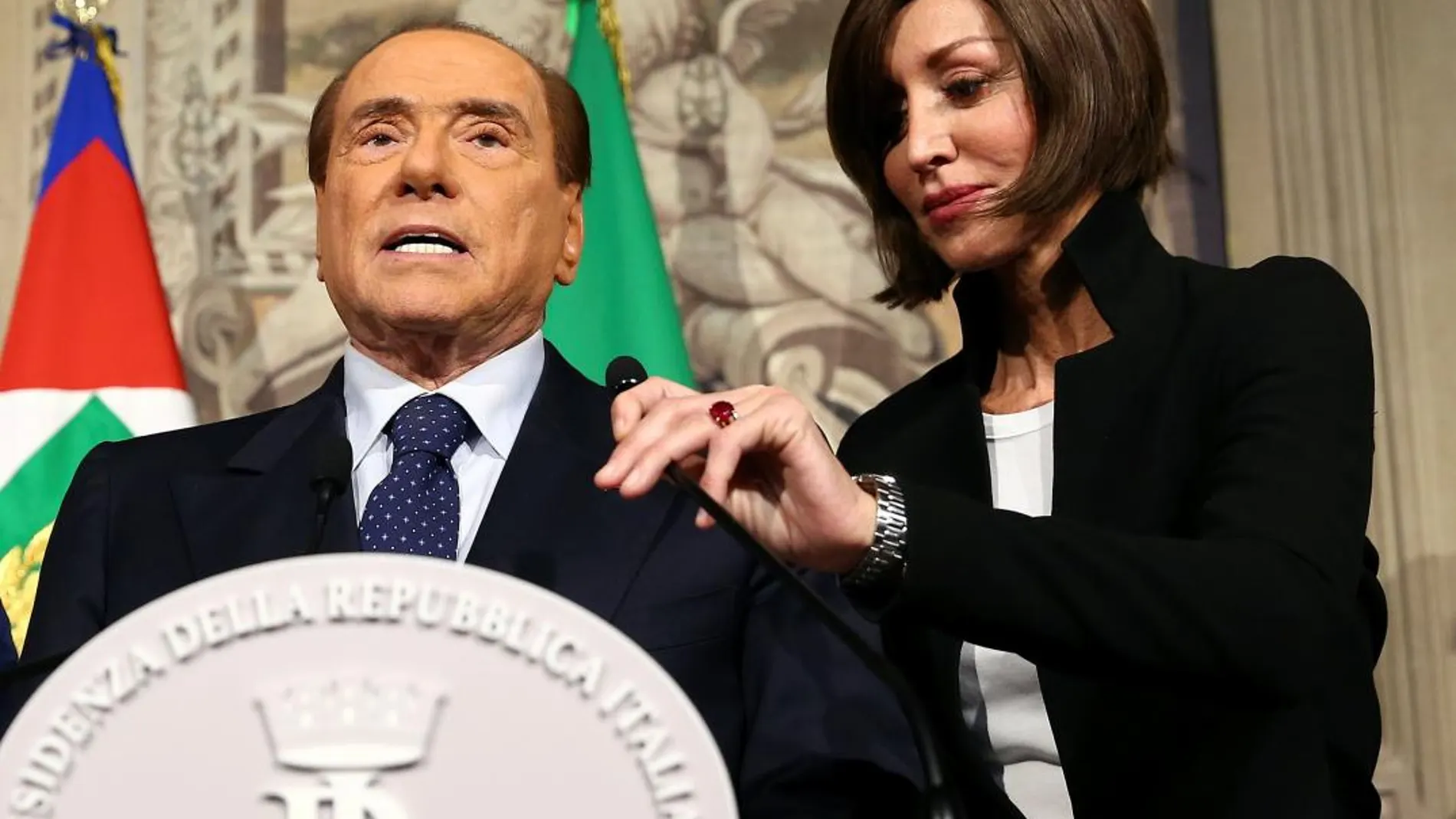 La senadora de Forza Italia, Anna Maria Bernini, coloca el micrófono de Silvio Berlusconi antes de la rueda de prensa, hoy en Roma