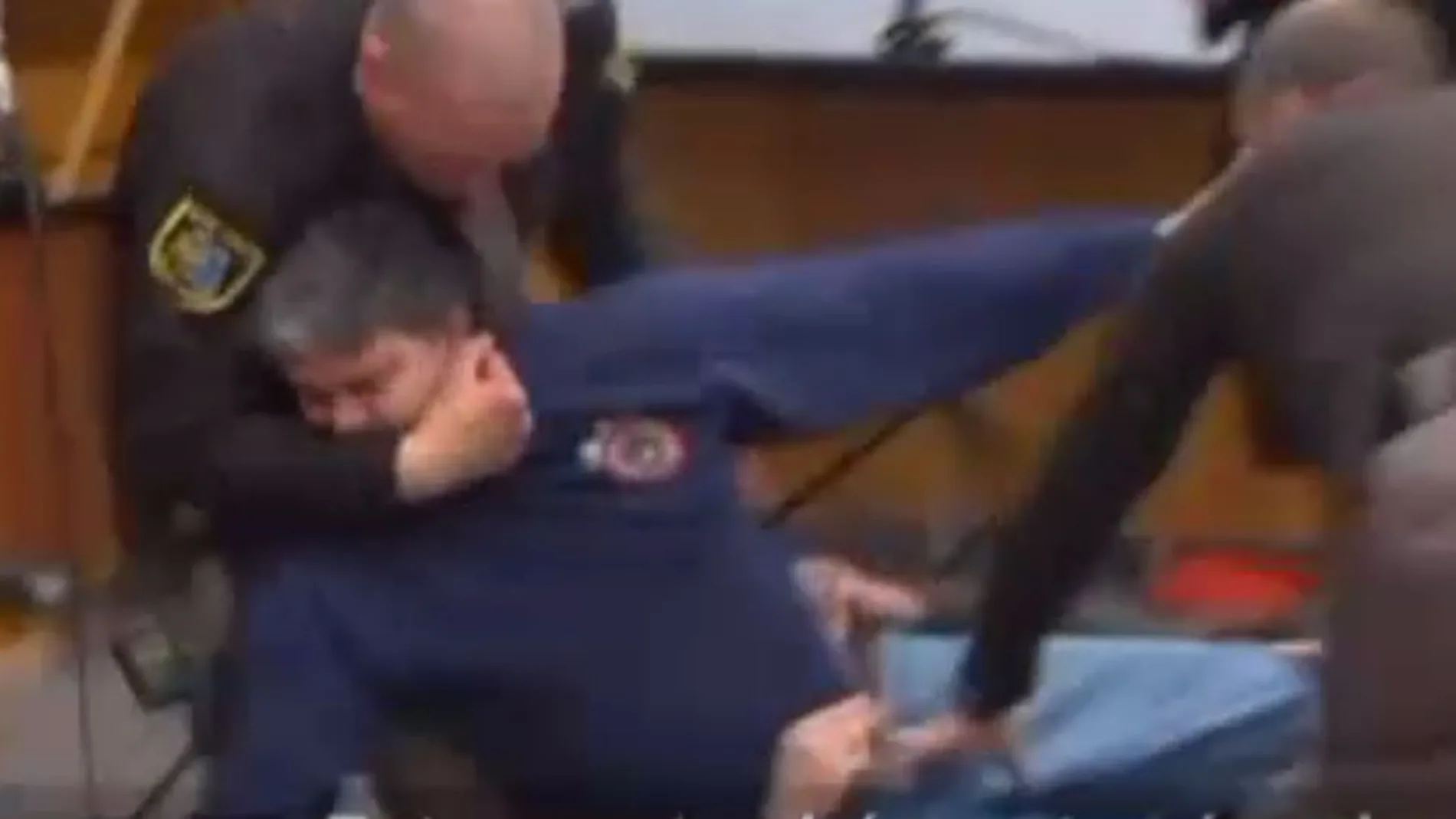 Momento en que el padre de las gimnastas es reducido por los policías del tribunal/Atlas