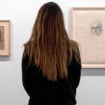Una obra de arte de 50 años, una mujer contempla dos de los retratos que realizó Tàipes a Teresa Barba desde 1946