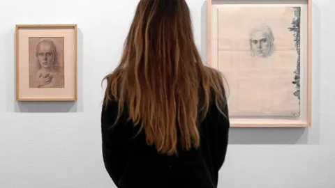 Una obra de arte de 50 años, una mujer contempla dos de los retratos que realizó Tàipes a Teresa Barba desde 1946