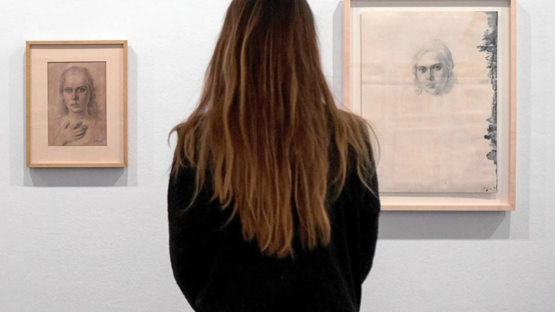 Una obra de arte de 50 años, una mujer contempla dos de los retratos que realizó Tàipes a Teresa Barba desde 1946