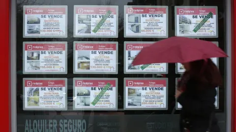 Imagen de archivo de carteles de "se vende" en el escaparate de una inmobiliaria