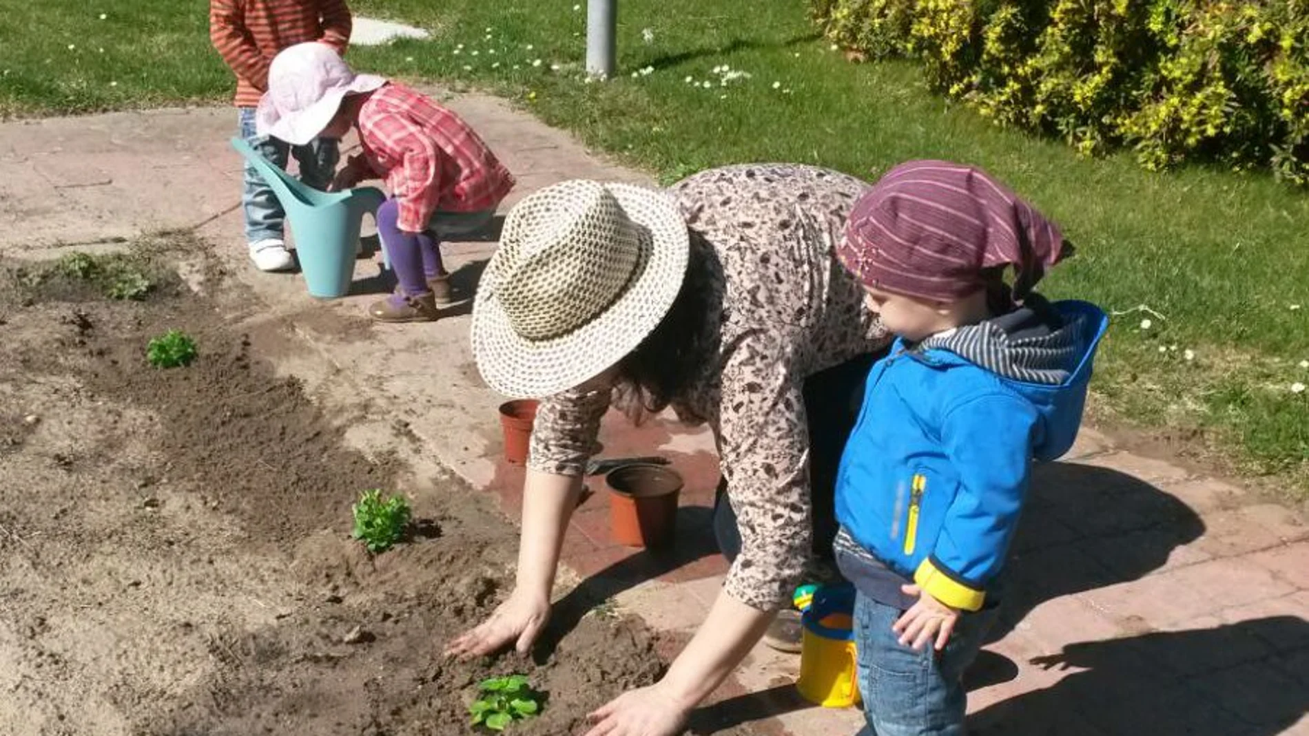Sobre estas líneas, Belén enseña a los niños que tiene a su cargo a plantar un pequeño huerto para que aprendan el desarrollo de la naturaleza