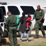 Agentes migratorios estadounidenses interceptan a una familia tras ingresar a territorio norteamericano por la valla fronteriza que separa México de Estados Unidos, el pasado mes de marzo / Efe