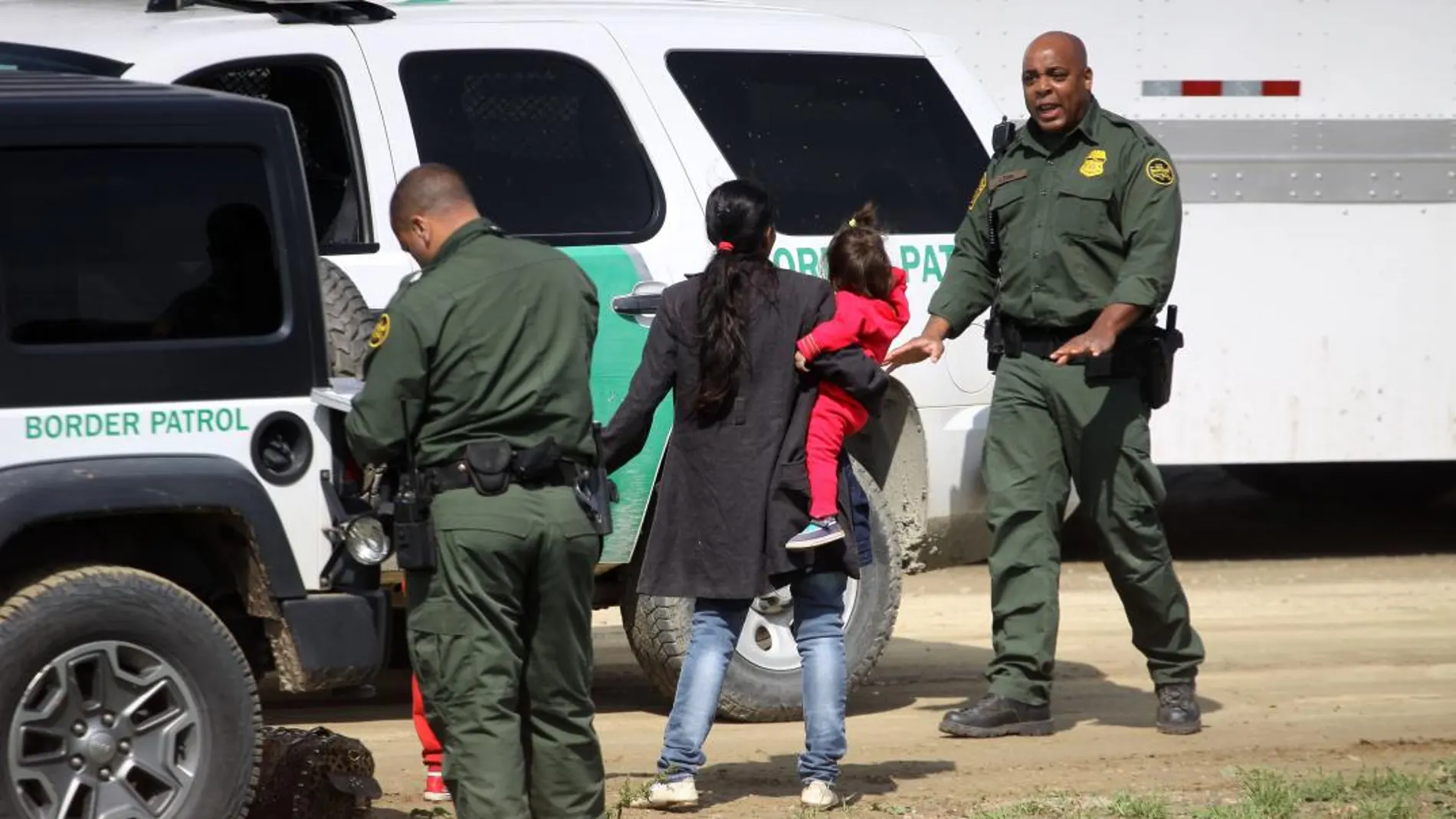 Agentes migratorios estadounidenses interceptan a una familia tras ingresar a territorio norteamericano por la valla fronteriza que separa México de Estados Unidos, el pasado mes de marzo / Efe