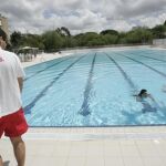 Un socorrista mira con atención a dos bañistas en una piscina