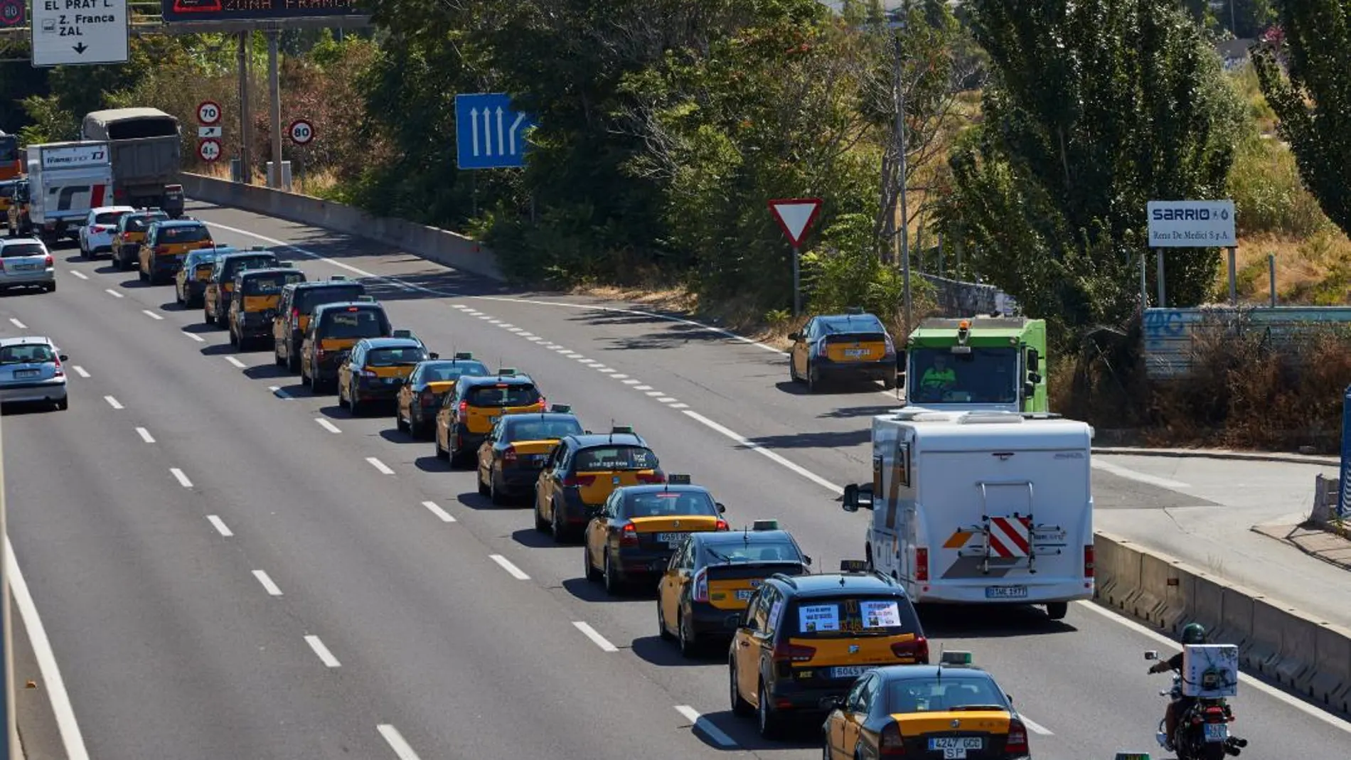 Cientos de taxistas en la marcha lenta desde al aeropuerto de El Prat hasta el puerto de Barcelona por la Ronda Litoral, en la segunda jornada de huelga en protesta por la suspensión cautelar del reglamento metropolitano que regula las licencias VTC / Efe
