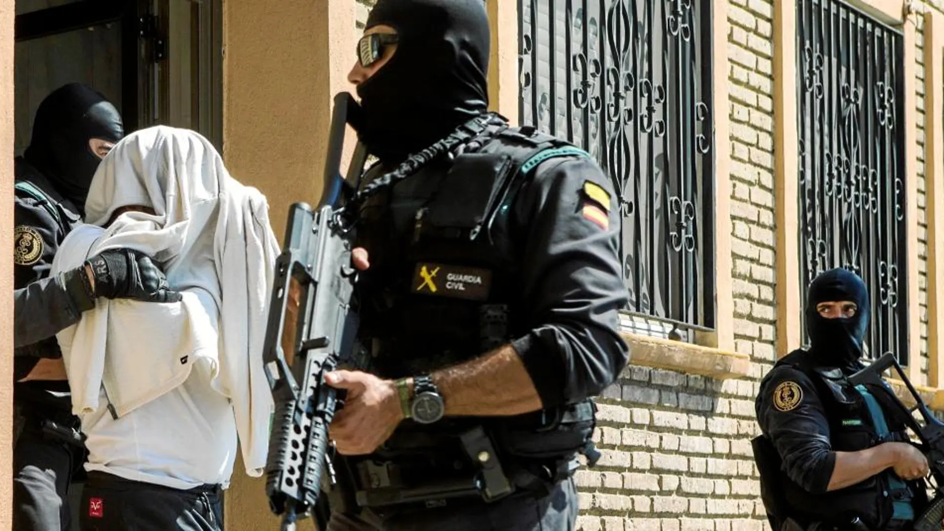 Agentes de la Guardia Civil, ayer, en Mataró, tras el registro efectuado en la vivienda de uno de los terroristas detenidos (en la imagen) / Efe