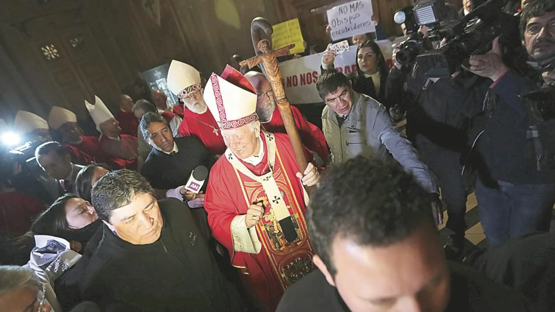 El arzobispo de Santiago, Ricardo Ezzati, a su entrada a la catedral mientras algunos fieles protestan por los casos de abusos