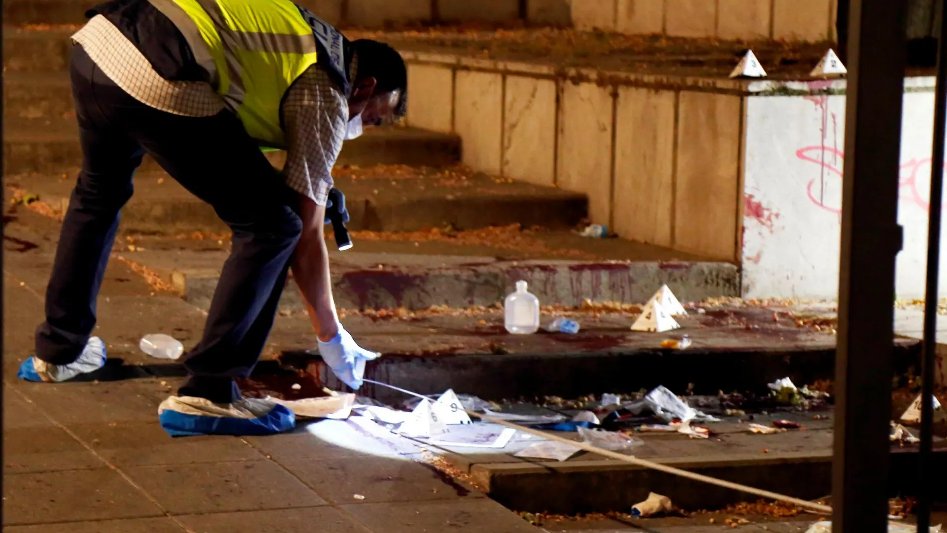 Miembros de la policía científica inspeccionan el lugar donde un hombre ha herido de gravedad con arma blanca a su supuesta expareja, en la céntrica Plaza de la Libertad de Granada.