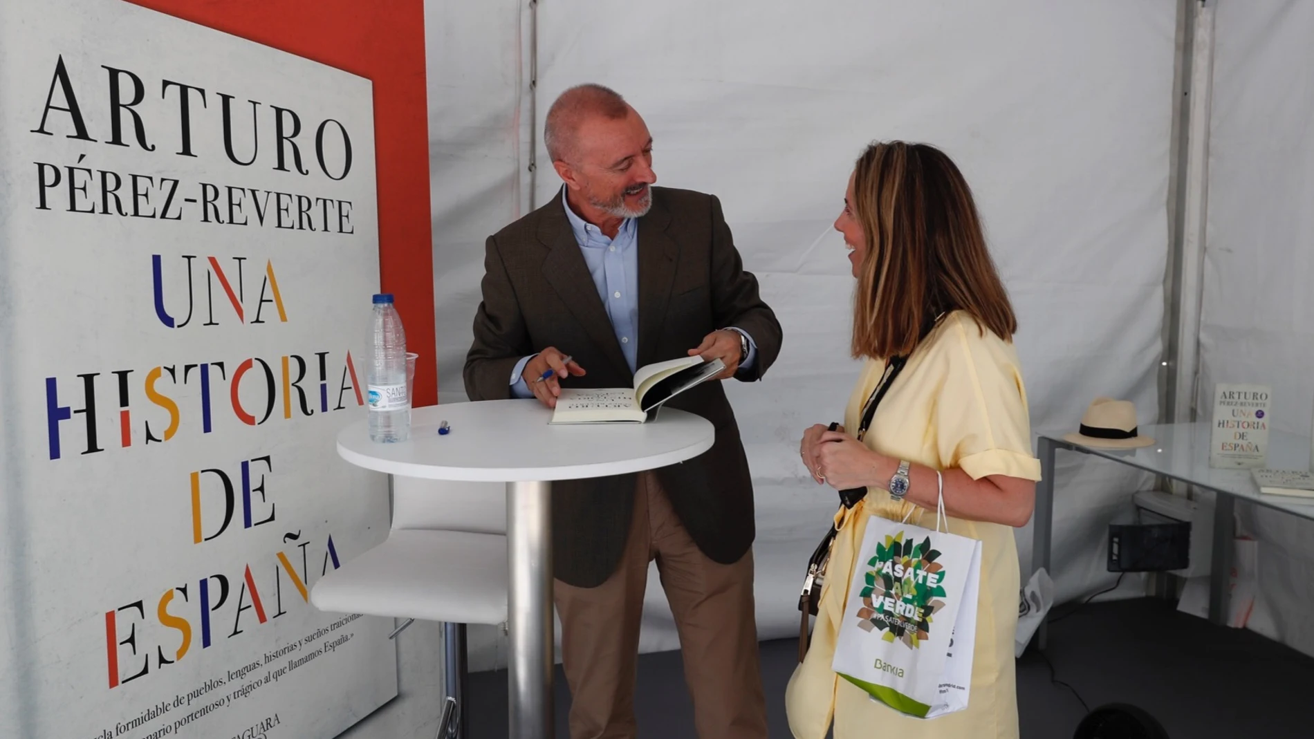 Arturo Pérez-Reverte, estilográfica en mano, dispuesto a rubricar uno de sus libros a una lectora
