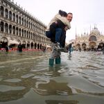 Un hombre carga a sus espaldas con su hija en la Plaza de San Marcos, inundada como consecuencia del temporal de lluvia registrado en Venecia el pasado mes de noviembre