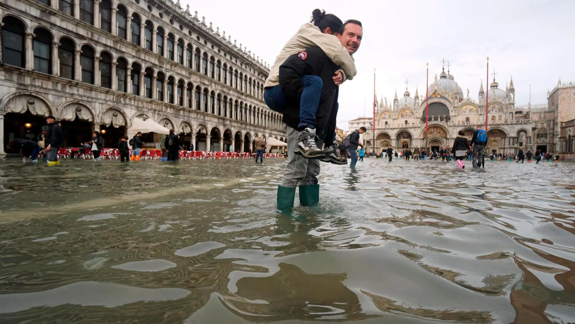 Un hombre carga a sus espaldas con su hija en la Plaza de San Marcos, inundada como consecuencia del temporal de lluvia registrado en Venecia el pasado mes de noviembre