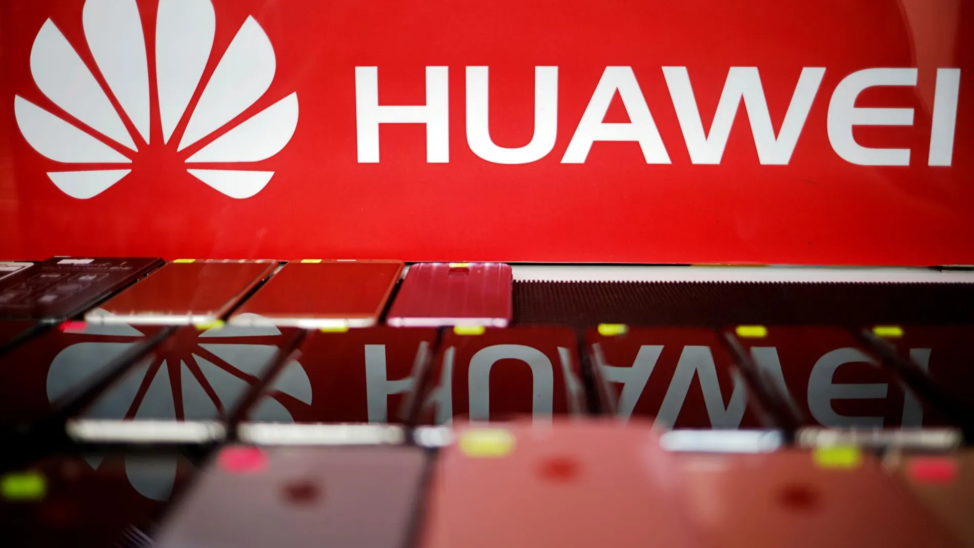 El logo de Huawei se refleja en unos móviles en una tienda de Singapur