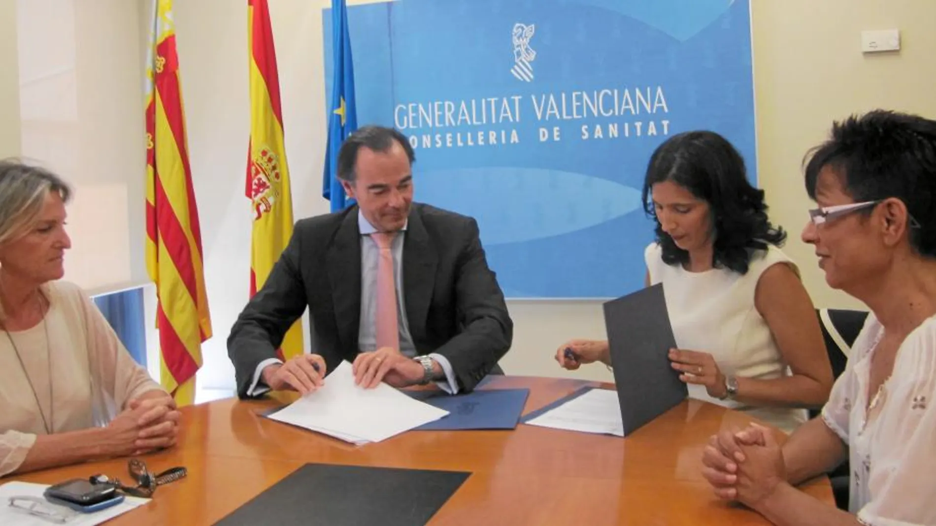 El conseller de Sanidad, Manuel Llombart, durante la firma del convenio con la presidenta de ALCE, Llanos Solves