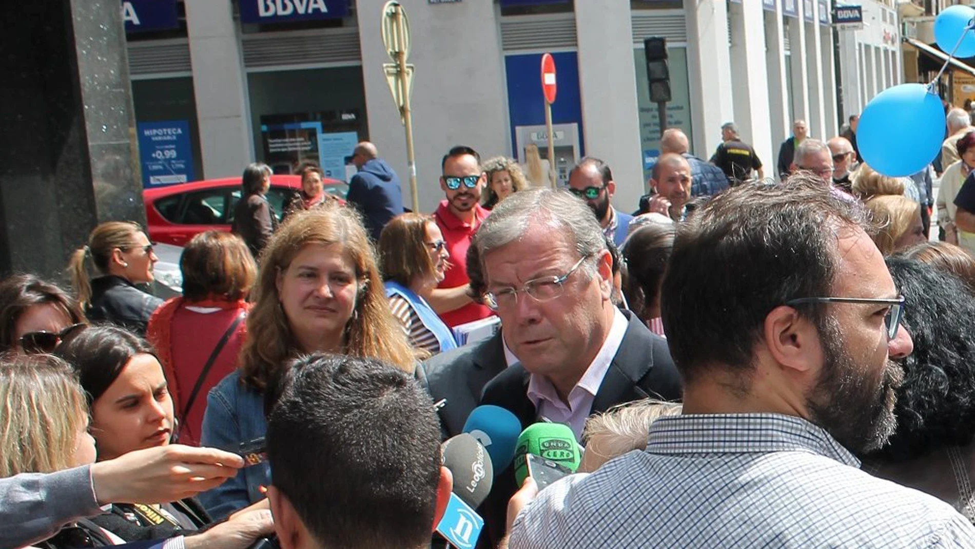 Antonio Silván atiende a los periodistas junto a la carpa de campaña del PP