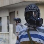 Un activista recoge posibles pruebas del supuesto ataque químico en Zamalka, Siria.