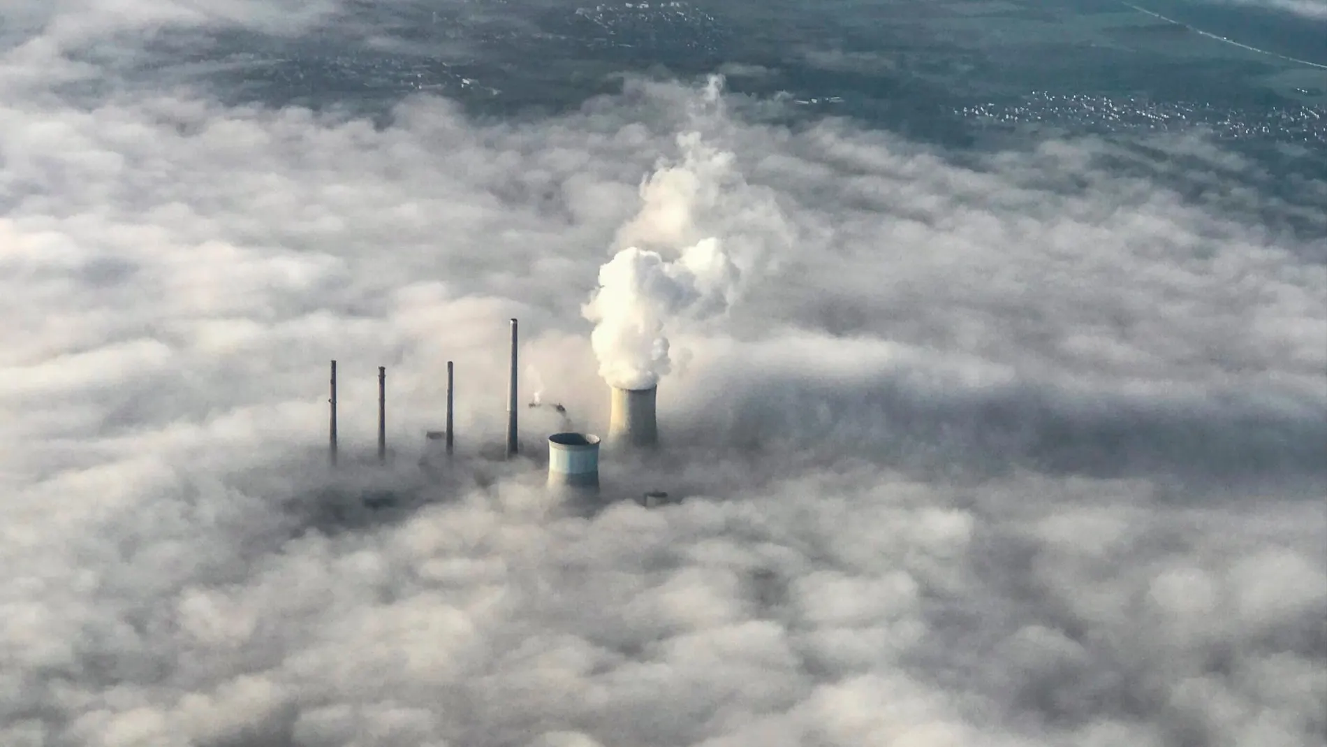 Un manto de humo envuelve las torres de refrigeración de una central térmica