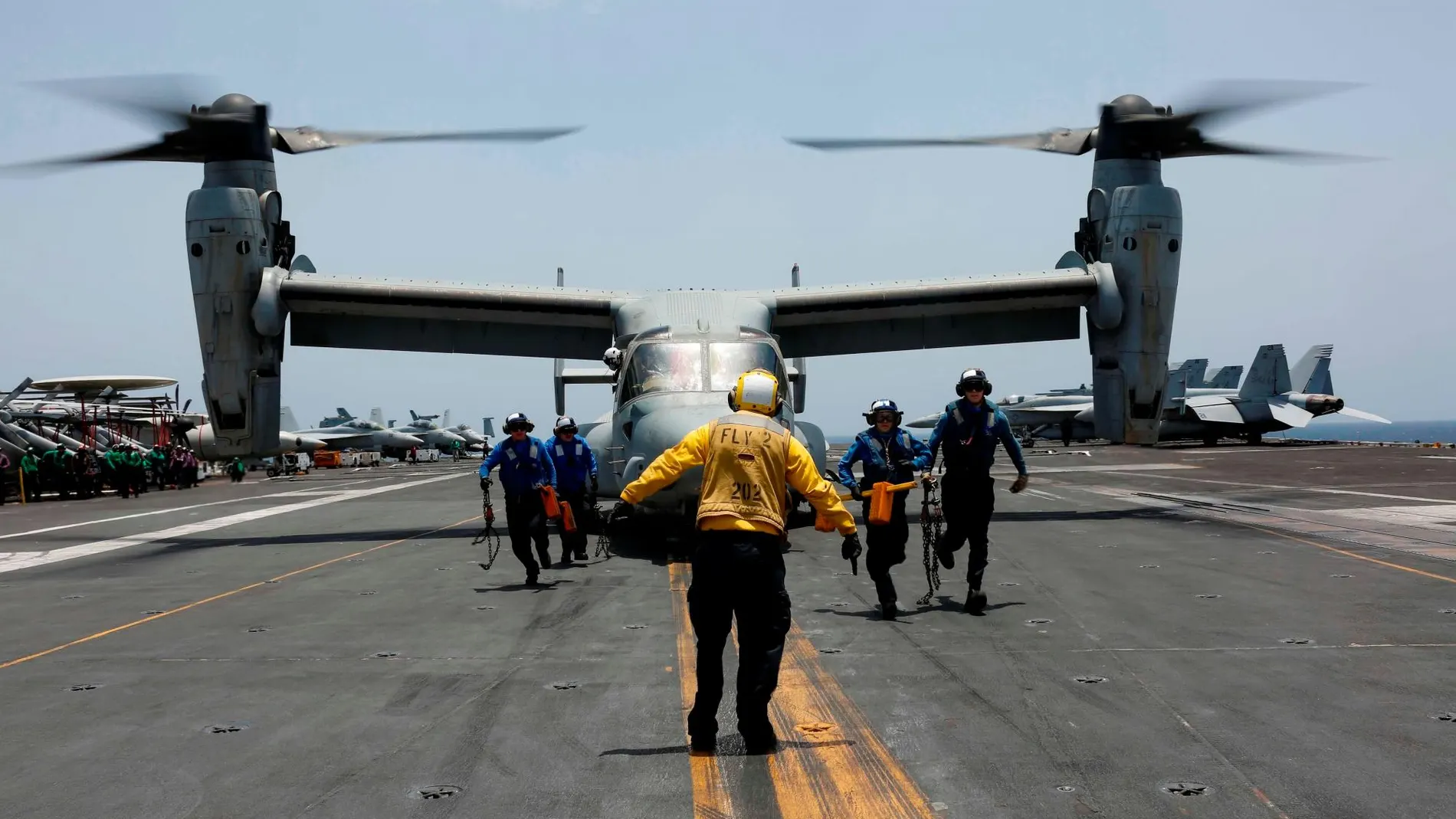 Varios marinos quitando cuñas a un MV-22 Osprey, del escuadrón Medium Tiltrotor 264 de la Marina