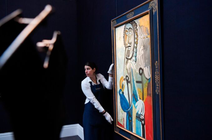 Una empleada de Sotheby's coloca la pintura "Hombre con una pipa", de Pablo Picasso, en la exposición de Arte Impresionista y Moderno en Londres / Foto: Efe
