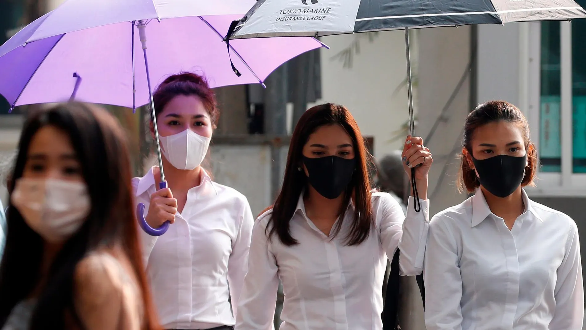 Varias muchachas llevan mascarillas mientras caminan por una calle de Bangkok (Tailandia) hoy, 15 de enero de 2019 / Efe