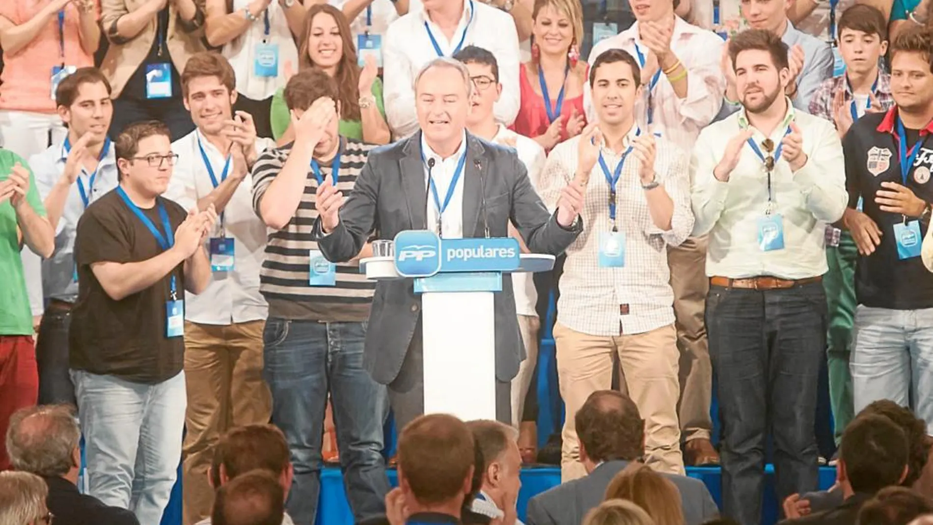 Arriba, el presidente Alberto Fabra en el momento en que consiguió levantar al público