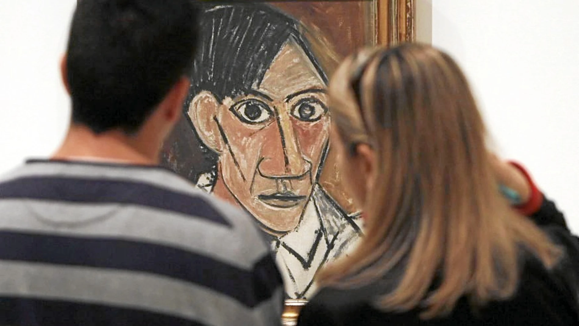 Dos visitantes de la muestra contemplan un autorretrato de Picasso de 1907