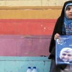Una mujer iraní sostiene un cartel electoral del candidato ultraconservador Said Jalili tras asistir a un mítin en Teherán