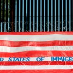 Roberto Márquez coloca un bandera americana en la que ha escrito «EE UU es un país de inmigrantes» en la frontera del Paso (Texas)
