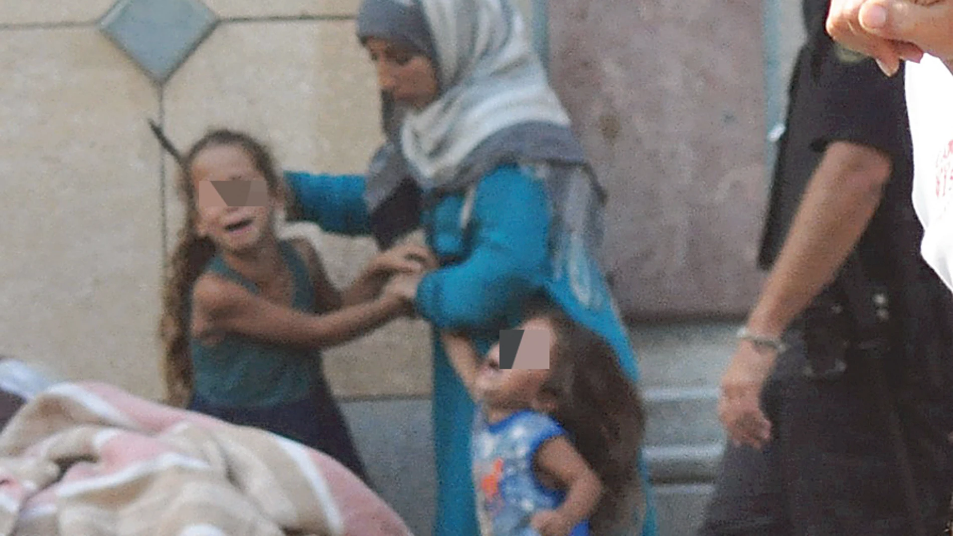Una mujer siria amenaza a sus hijas con un cuchillo