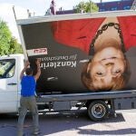 Varios trabajadores desmontan un cartel electoral de Angela Merkel en Stuttgart