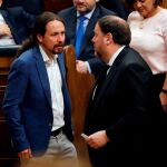 El líder de Podemos, Pablo Iglesias (i), conversa con el diputado electo en prisión preventiva de ERC Oriol Junqueras (d),