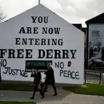 Vecinos de Derry junto a un grafiti que dice: «Sin justicia no hay paz»/EFE