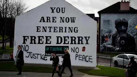 Vecinos de Derry junto a un grafiti que dice: «Sin justicia no hay paz»/EFE