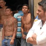 Jalis de la Serna posa delante de presos tatuados en una cárcel latinoamericana