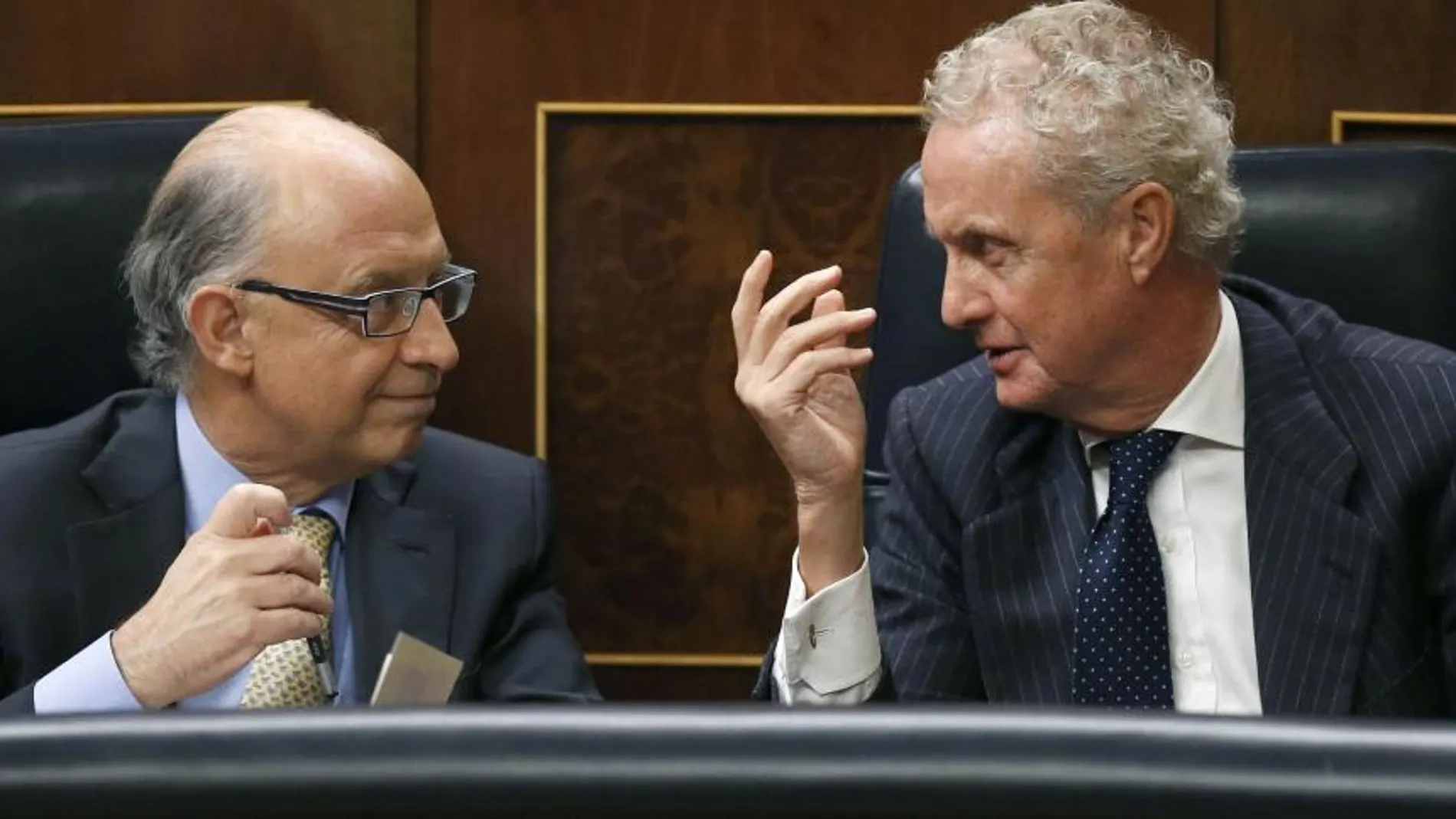 El ministro de Hacienda, Cristóbal Montoro, conversa con el de Defensa, Pedro Morenés, durante el pleno de Congreso de los Diputados