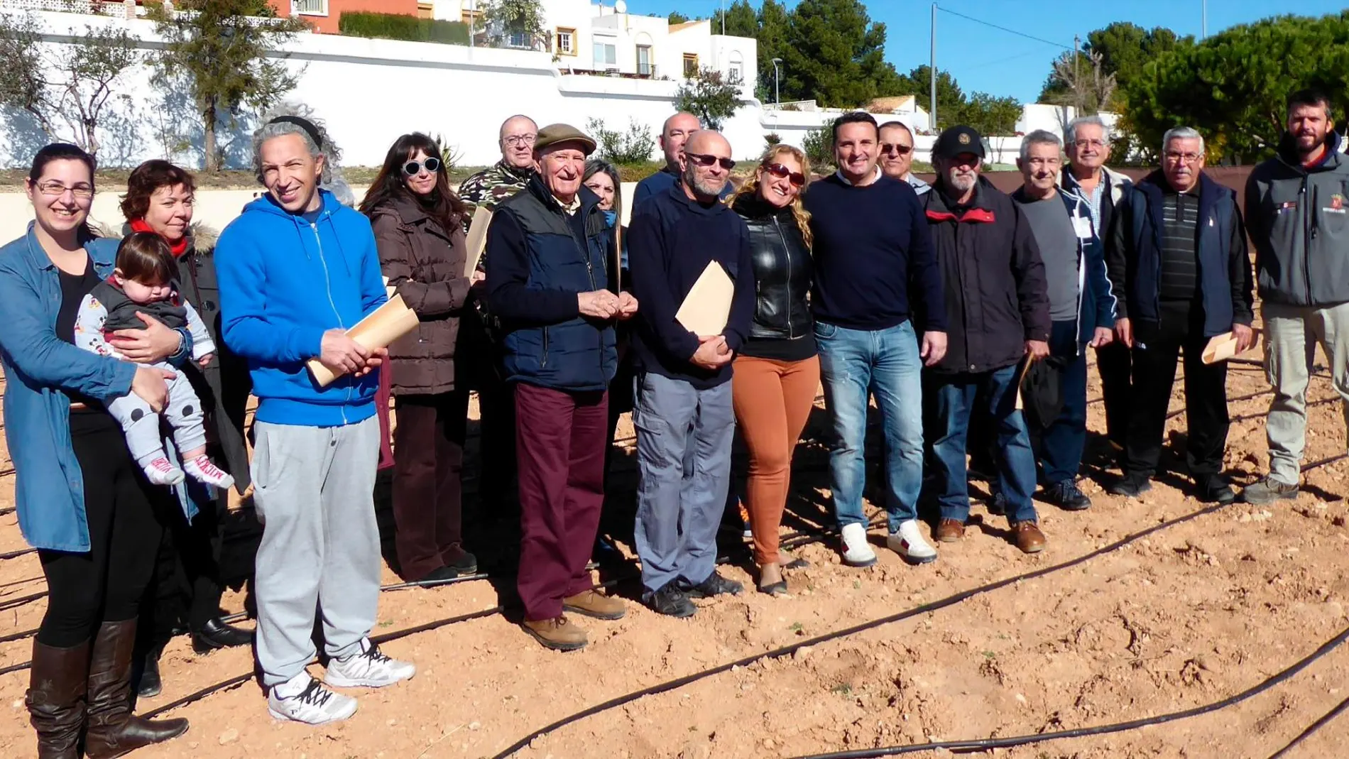 Los 21 vecinos que ha recibido nuevas parcelas en el ecohuerto, junto al alcalde de La Nucía, Bernabé Cano, durante la entrega de terrenos