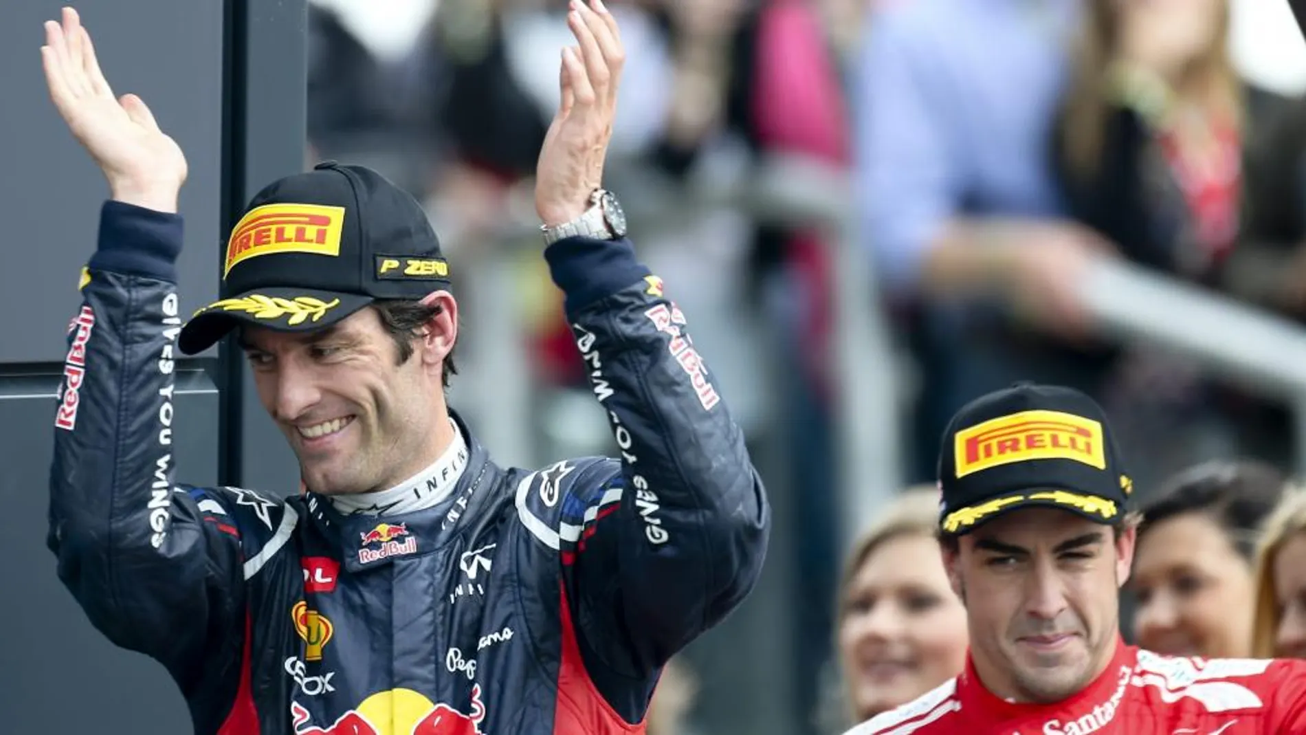 El piloto australiano de Fórmula Uno Mark Webber, de Red Bull, y el español Fernando Alonso (d), de Ferrari, suben al podio tras el Gran Premio de Gran Bretaña de Fórmula Uno