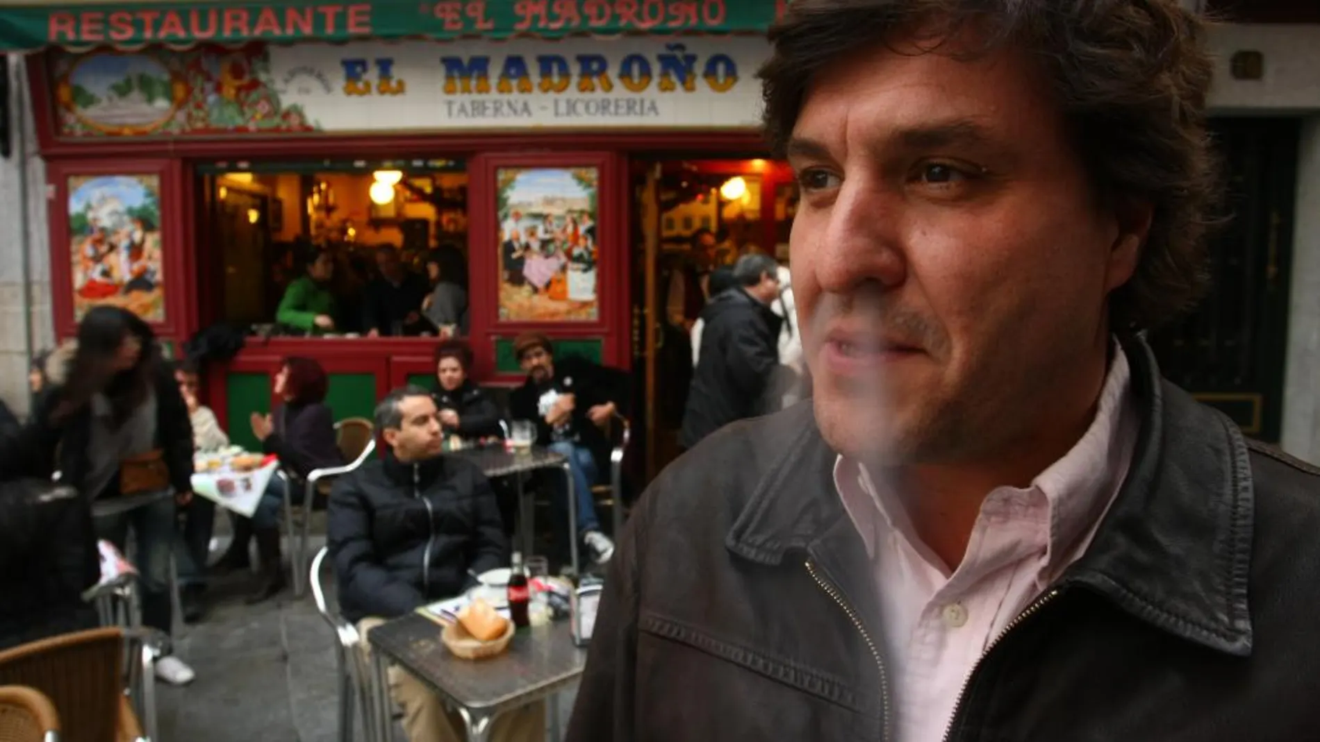 Un fumador, a la puerta de un bar